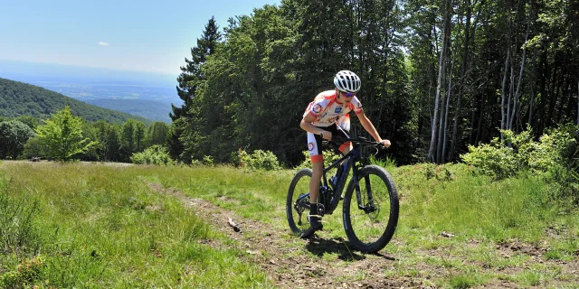 Un VTTiste grimpe La Planche des Belles Filles sur une chemin enherbé - Vosges du Sud