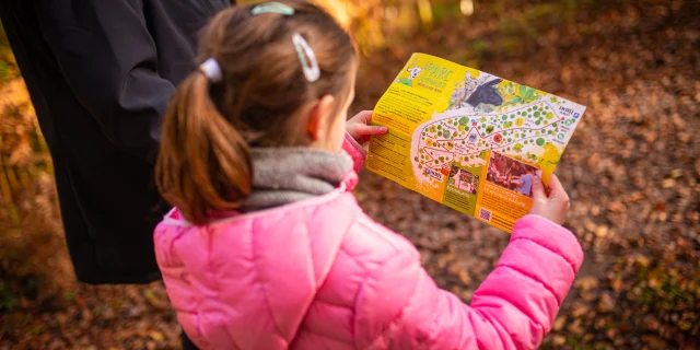 Une jeune fille tient dans ses mains le plan du Parc animalier de Fougerolles - Vosges du Sud