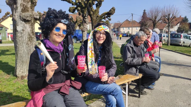 Les randonneurs sont assis sur des bancs et profitent d'une soupe concoctée par les bénévoles, à l'occasion de la randonnée des 6 Soupes - Vallée de l'Ognon