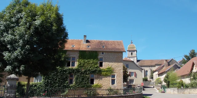 Vue d'ensemble de la Cité de caractère de Filain, avec son église au toit de tuiles vernissées en arrière-plan - Vallée de l'Ognon