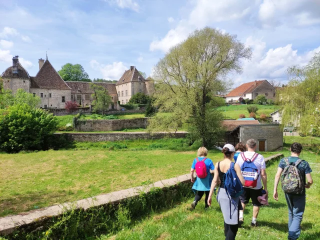 Des randonneurs arrivent dans la Cité de Caractère de Filain et aperçoivent au lieu le château - Vallée de l'Ognon