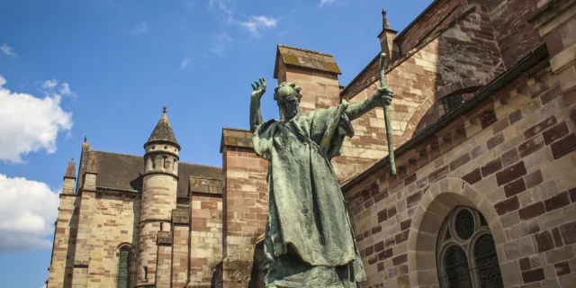 La statue en bronze de Saint Colomban érigée en 1947 accueille le visiteur devant la basilique Saint-Pierre de Luxeuil-les-Bains - Vosges du Sud